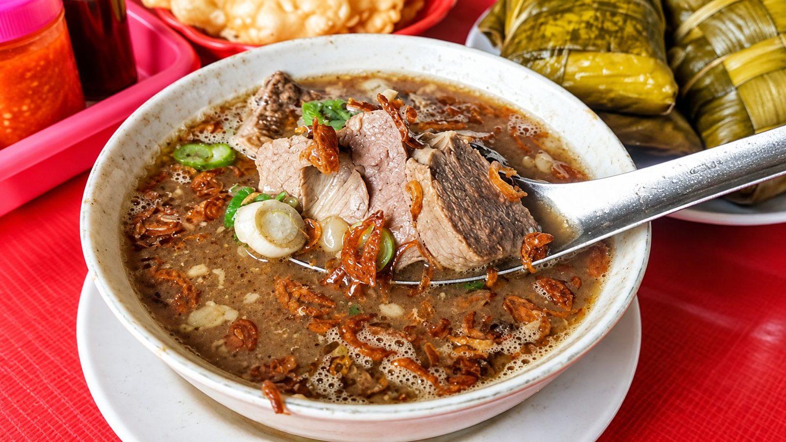 Sajian coto dengan ketupat burasa dan sambal tauco khas Makassar